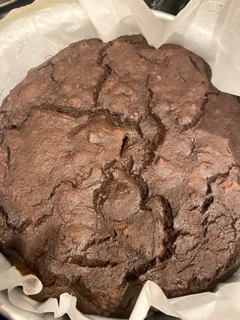 Baked chocolate cake in the pan with parchment paper underneath