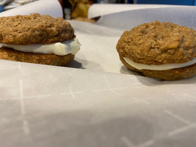 Two oatmeal cream pies. One is two cookies filled with cheddar cheese filling and the other is two cookies filled with sweet cream cheese filling.